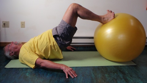 Coach John Hughes demonstrating ball hamstring curl exercise for core training for cycling