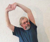 John Hughes demonstrating the overhead stretch for cyclists